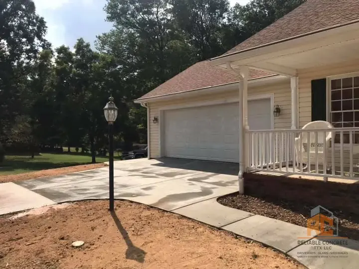 Driveway and front walk at a home with a white porch