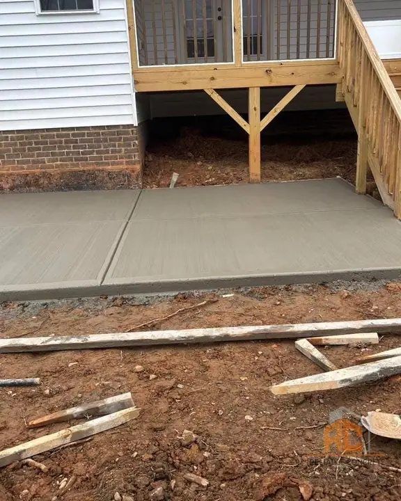 Concrete landing poured under a wooden deck stair