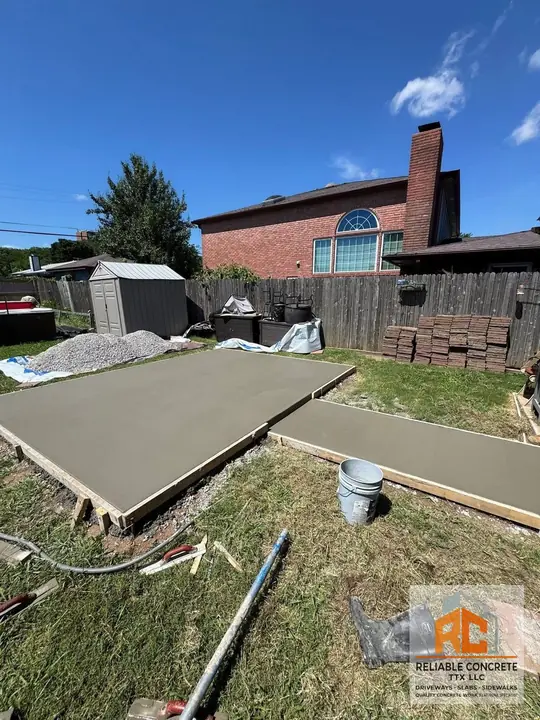Backyard patio slab next to a fence