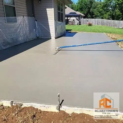 Back patio being finished beside a house