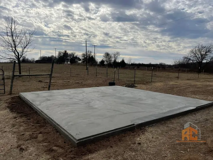 Square concrete pad in an open field