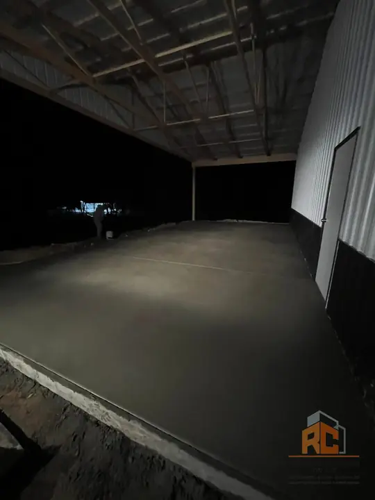Inside a metal shop building on a fresh concrete floor slab